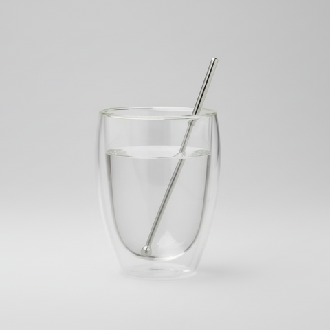 Clear glass with a Magnetic pencil on a light gray background