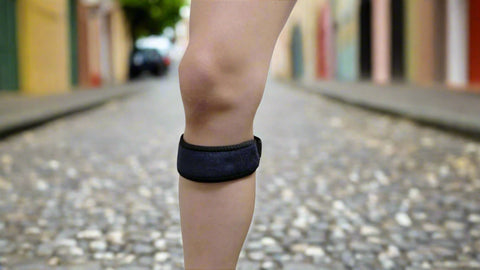 Person wearing a black Patella magnetic band on a blurred street background