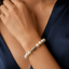 Pearl bracelet on a woman's wrist with a dark blue garment.