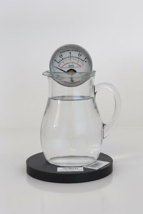 Clear glass pitcher over water magnet cylinder with a magnetometer 