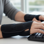 Man wearing wrist supports while typing at computer