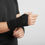 Person wearing magnetic wrist supports on both wrists